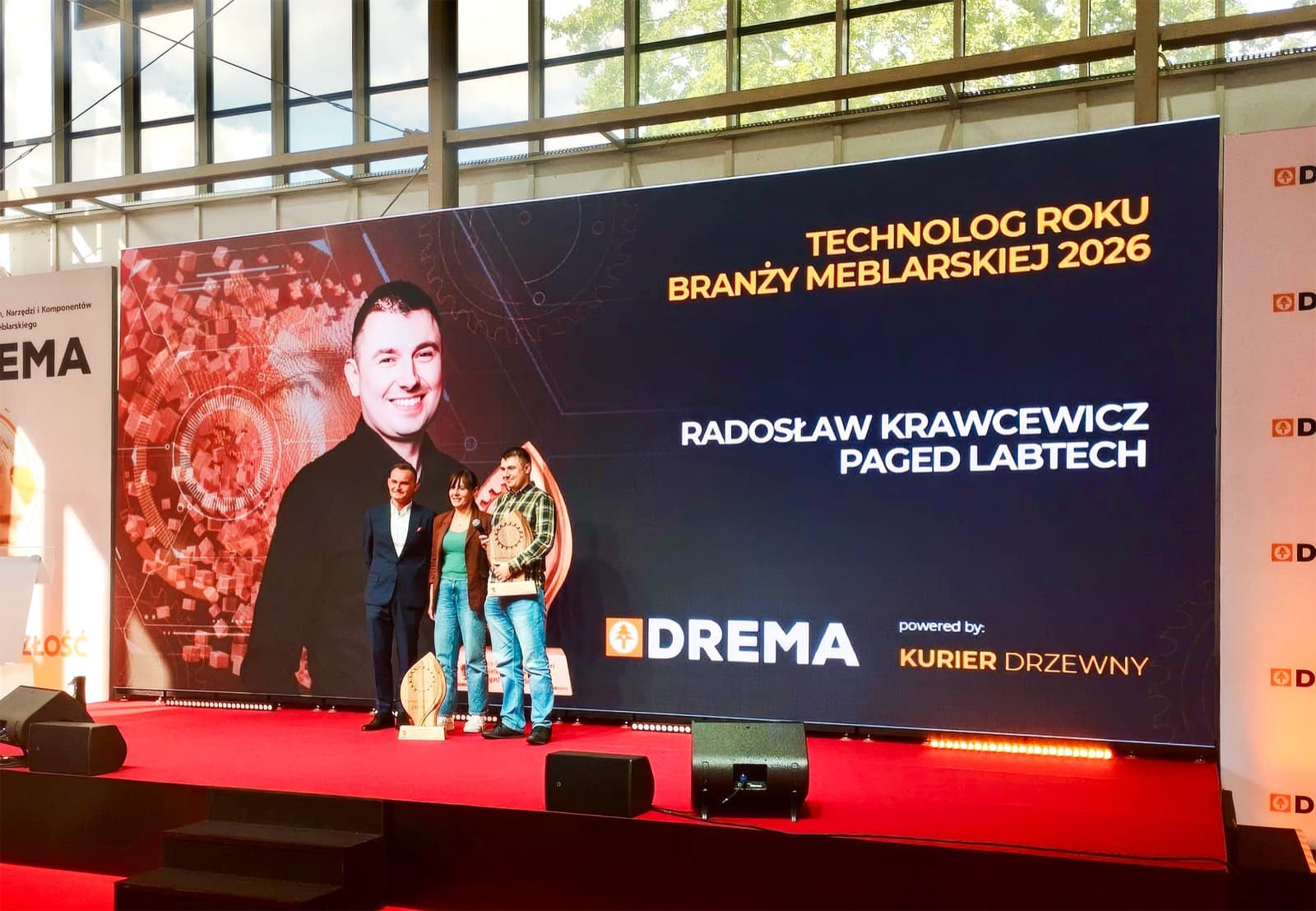 Radosław Krawcewicz z nagrodą na scenie III Forum Technologów podczas targów DREMA 2026, na ekranie napis „Technolog Roku Branży Meblarskiej 2026”